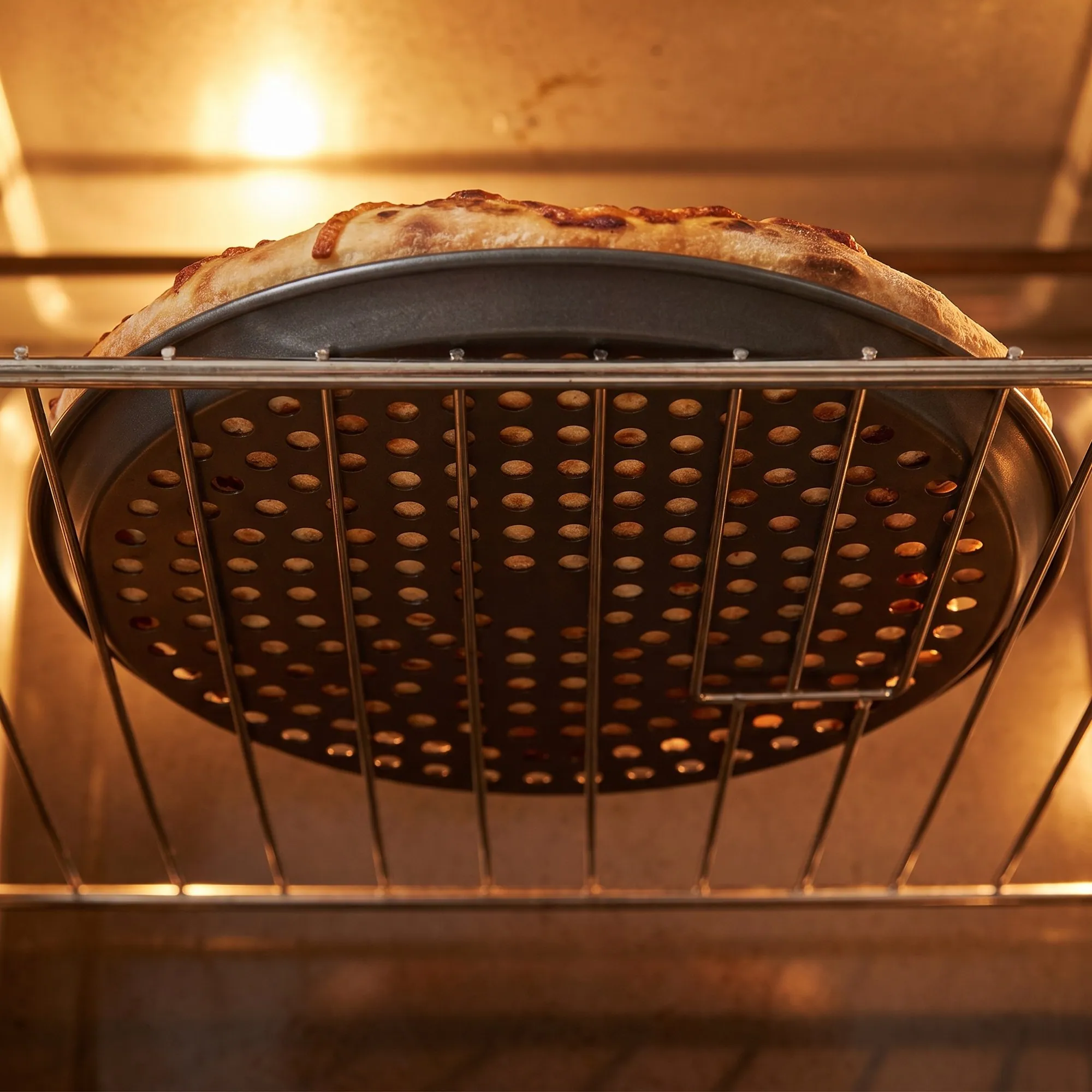 Fırında alttan görünüm: deliklerden geçen hava ve çıtır pizza tabanı